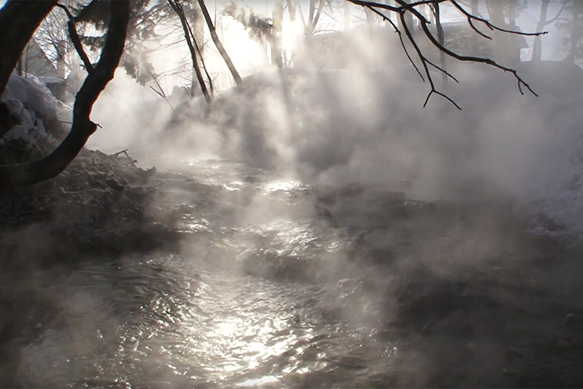 A small fall of hot spring running through the forest of red ezo pine